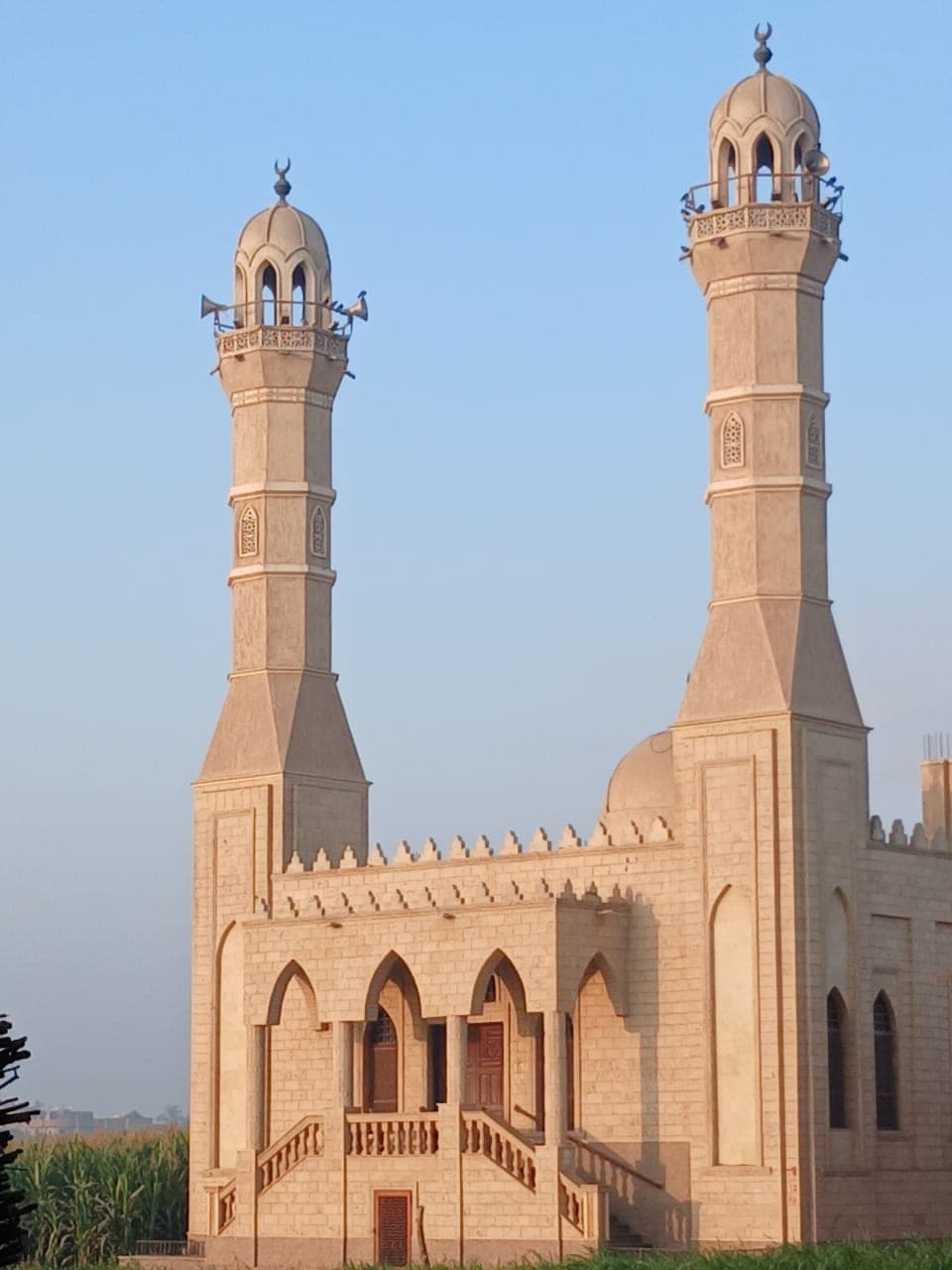 Almaghfera Masjid — the arched front elevation and entrance stairs beneath both minarets