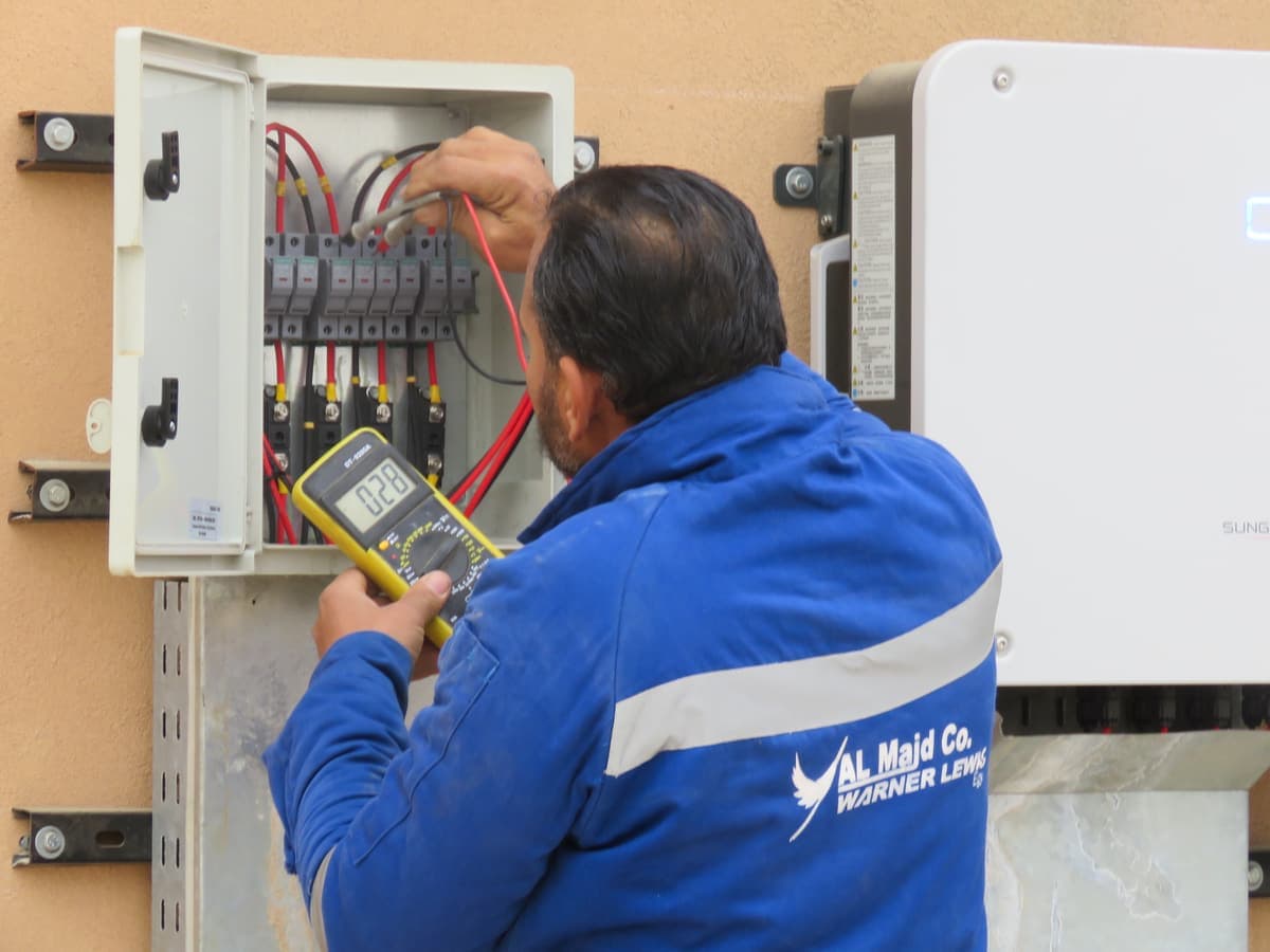Al Majd · Warner Lewis engineer taking commissioning measurements at the DC combiner box