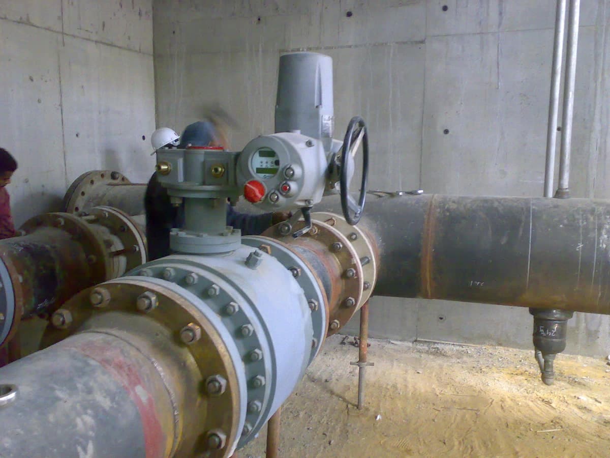 A motorised valve on flanged pipework inside a chamber at the Hurghada depot